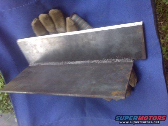 Welded metal part on blue cloth with gloves