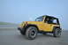 2004 Jeep TJ - A yellow 2004 Jeep TJ is parked on a sandy beach under a hazy sky.