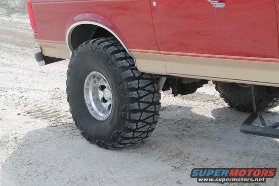 Red and tan SUV side view, large off-road tires. 1990 Ford Bronco