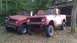 1961 International Scout 80 - Two vintage International Scout SUVs are parked outdoors next to a rustic wooden structure.