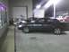 2003 Ford Crown Victoria - A dark 2003 Ford Crown Victoria is parked next to another car with its hood up.