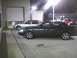 2003 Ford Crown Victoria - A dark 2003 Ford Crown Victoria is parked beside a silver sedan in a lot at night.