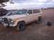1988 Ford Bronco - This Jeep Grand Wagoneer, likely from the mid-1980s, is parked outdoors next to another vehicle.