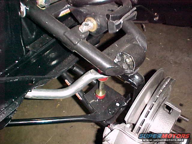 close-up of a car's front suspension components, including brake rotor and caliper
