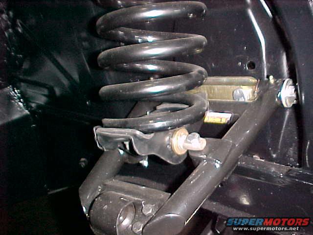 Black coil spring and suspension arm assembly with visible bolts and metal brackets