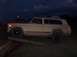 1988 Ford Bronco - This tan SUV with a red stripe is seen from the side as dusk settles.