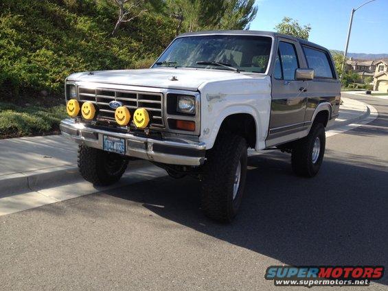 1980s Ford Bronco with four yellow smiley face fog lights mounted on the front bumper