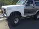 1986 Ford Bronco - This lifted Ford Bronco shows a two-tone paint scheme with a white front fender and gray side panel.