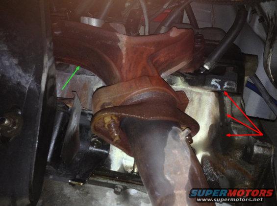 Exhaust manifold bolted to engine block with visible '58' marking