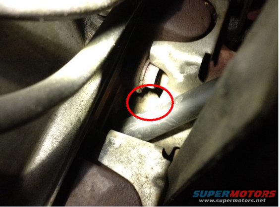 Close-up of engine components with a red circle highlighting a small part