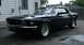 1969 Ford Mustang - A black 1969 Ford Mustang convertible is shown from a three-quarter front view in a driveway.