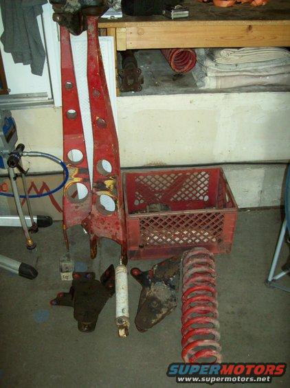 Red suspension components and red coil spring on garage floor