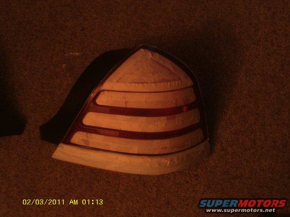 Car taillight with horizontal red and clear sections, taped edges