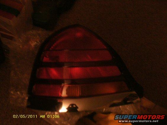 Close-up of a red car tail light assembly with horizontal amber turn signal section