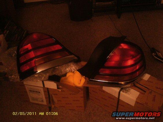 Two red car tail lights are sitting on top of cardboard boxes