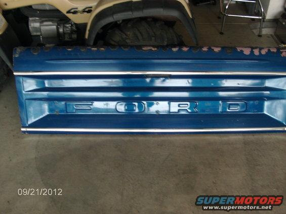 Blue Ford tailgate with chrome trim and raised lettering