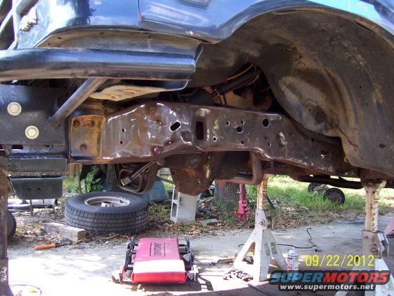 Frame and suspension of a vehicle on jack stands, with a spare tire visible