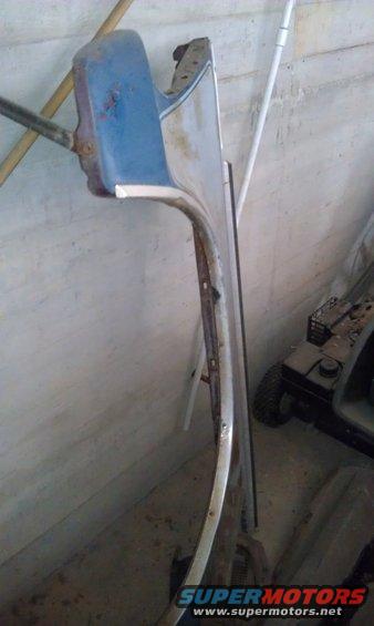 Blue and chrome car fender leaning against a wall