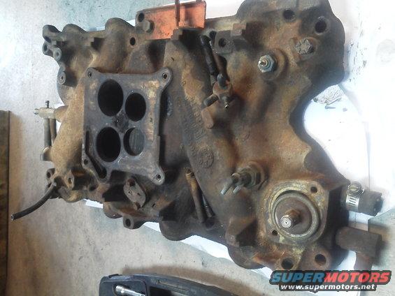 Rusty engine intake manifold with four carburetor mounting holes