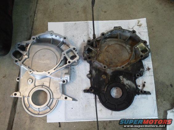 Clean and dirty timing chain covers side-by-side on a paper on the floor