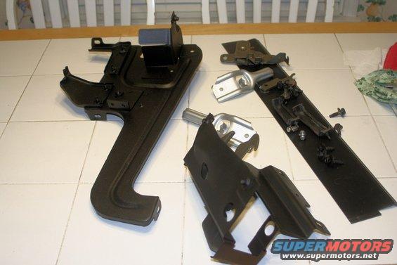 black metal automotive parts laid out on a tiled floor
