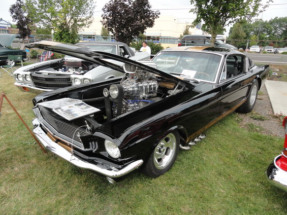 Black 1965 custom coupe with supercharger and side pipes