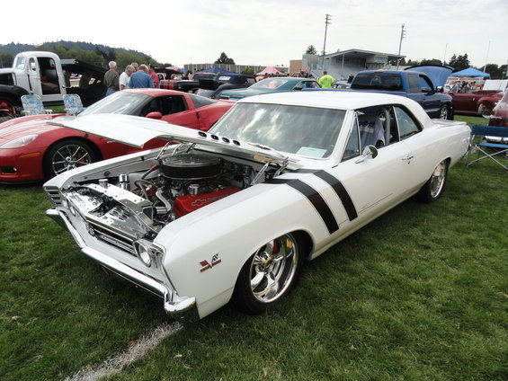 White 1967 Chevrolet Chevelle SS with black stripes on fender and door, hood open showing engine