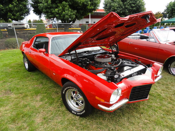 Red 1970 Chevrolet Camaro with hood open, showing engine and chrome details