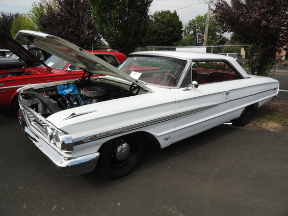 1964 Ford Fairlane with hood open, red interior, parked next to a red car