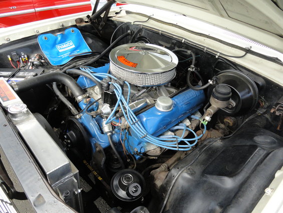 Engine bay with blue Ford-branded valve covers and a chrome air cleaner with an orange 390 sticker