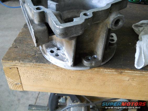 Metal engine part on a wooden workbench, with a white cloth to the right