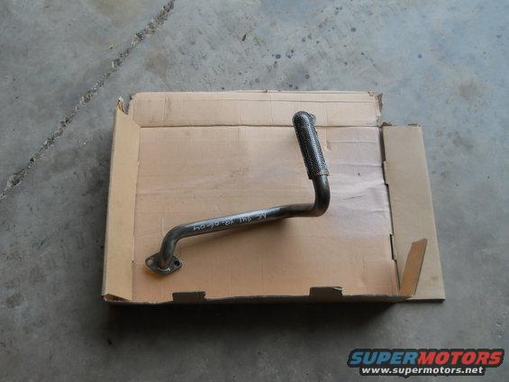 metal exhaust pipe with flange and textured end, sitting in a cardboard box