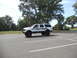 2001 Ford Excursion - A white Ford Excursion is parked in a lot, modified with a lift kit and custom graphics.