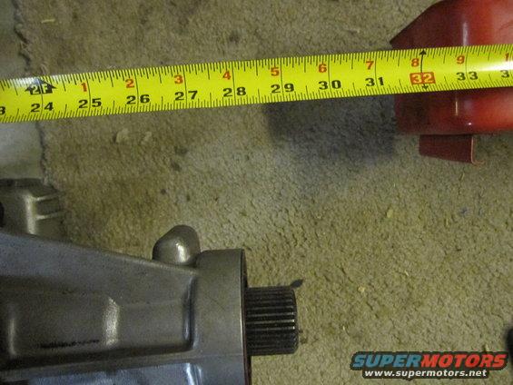 Measuring tape over a metal automotive part, showing about 30 inches