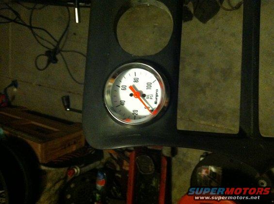 Oil pressure gauge with red needle on 40 PSI, mounted in black dashboard trim