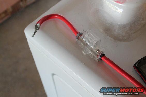 Red wire with inline fuse holder on white surface