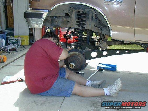 Person working on the front suspension of a 1993 Ford F-150