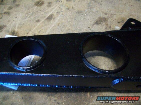Black metal bracket with two large circular holes and a mounting tab