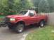 1996 Ford F-150 - A red pickup truck is parked in a driveway, with its front end slightly elevated.