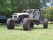 1967 Ford Mustang - Custom off-road buggy with a roll cage and oversized tires sits on grassy terrain.