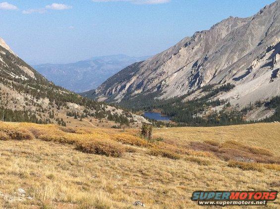 Mountain valley with a small lake and autumn foliage in the foreground