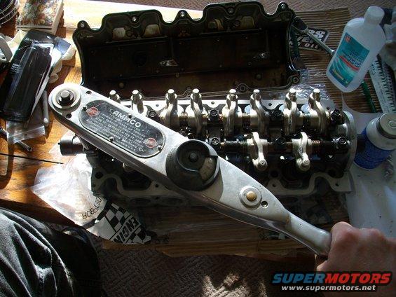 Engine valve train with AMMCO torque wrench on a wooden surface