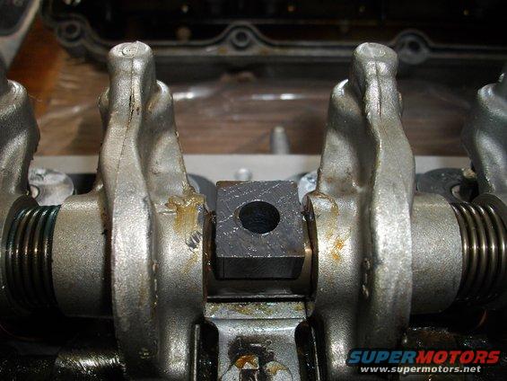 Close-up of engine valve train with rocker arms and a central block