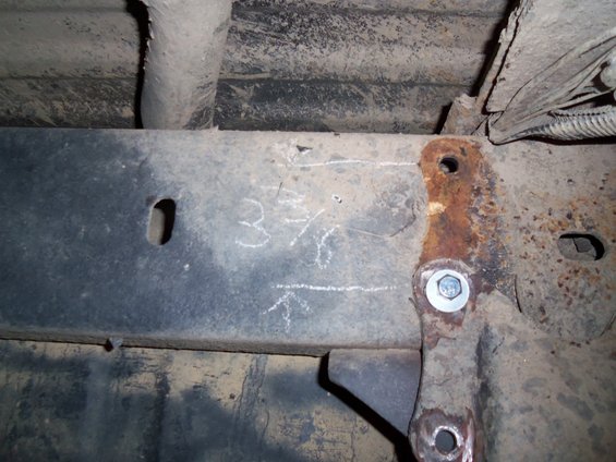 Rusty metal frame with chalk markings '3 7/16' and an arrow