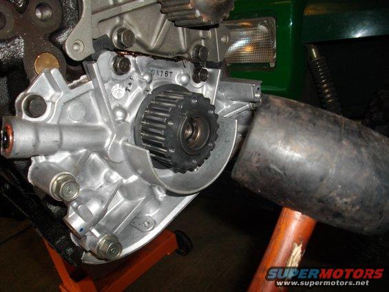 Close-up of engine component with a rubber mallet nearby. Text 'DA167' visible on metal
