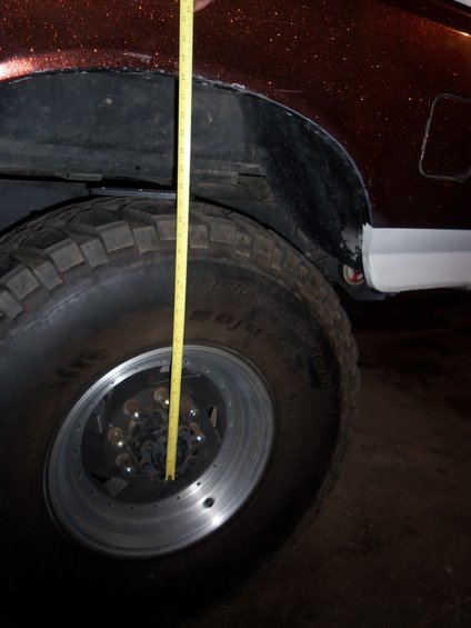 Measuring tape against a large off-road tire and wheel well