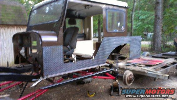 Brown Jeep CJ-5 body on a trailer, missing front fenders and hood