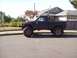 1985 Toyota Pickup/SR5 - Side view of a modified 1985 Toyota Pickup SR5 with large tires and a lifted suspension.