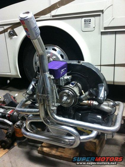 Volkswagen engine with custom exhaust and a beer can on the intake