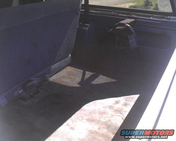 Rear cargo area of a vehicle with folded-down seats and a spare tire cover